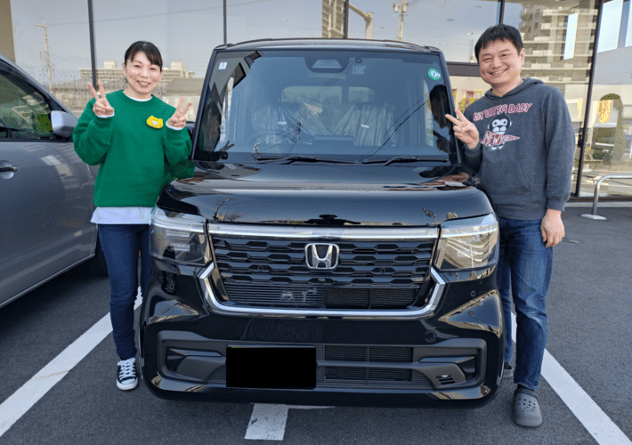 車と写真を撮る夫婦